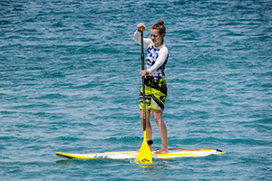 A Women Stand Up Paddle Boarding in the Sea Beach